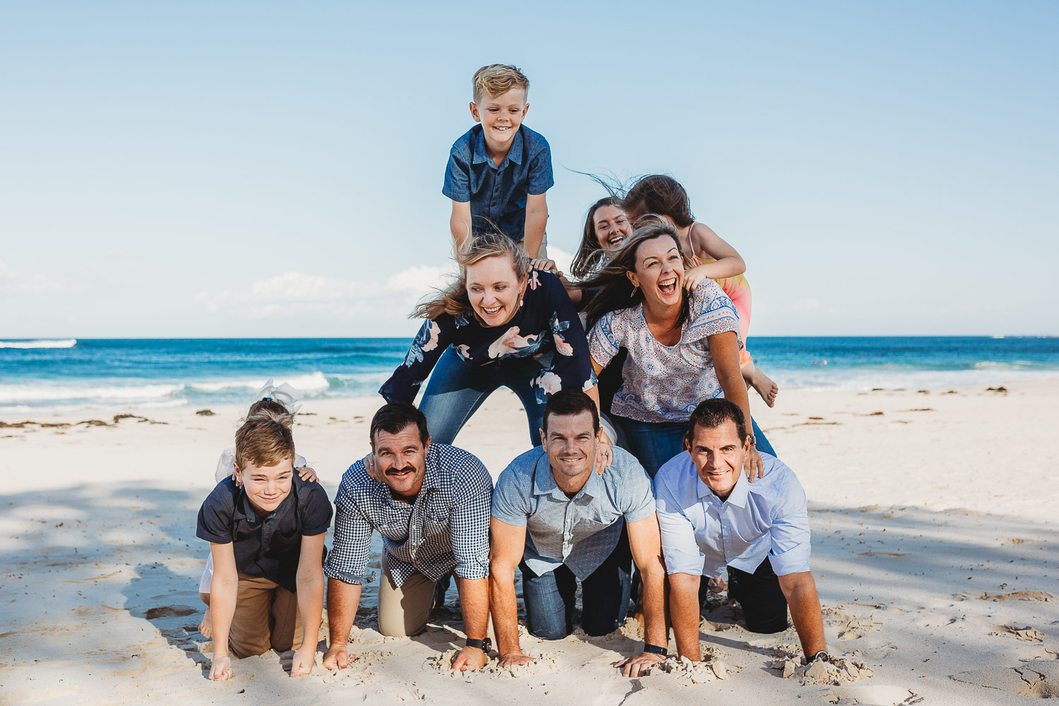 Family laughing and smiling while attempting human pyramid