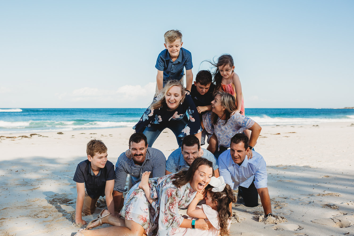 Family builds human pyramid while laughing and smiling