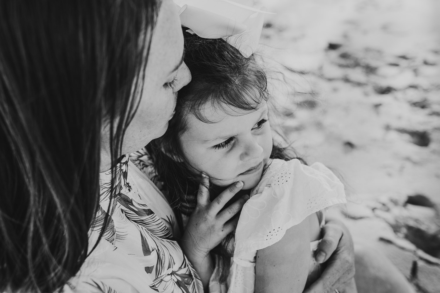 Black and white image mother kissing daughter on the forehead