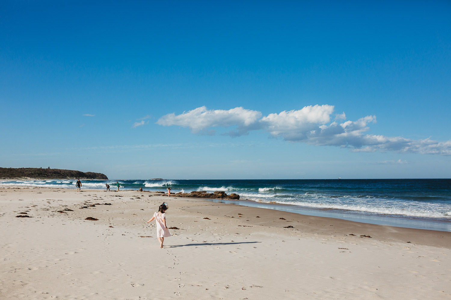 Young girl walking on the beach toward water