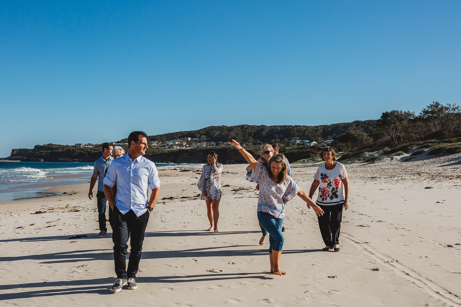 Adults walking and laughing on the beach