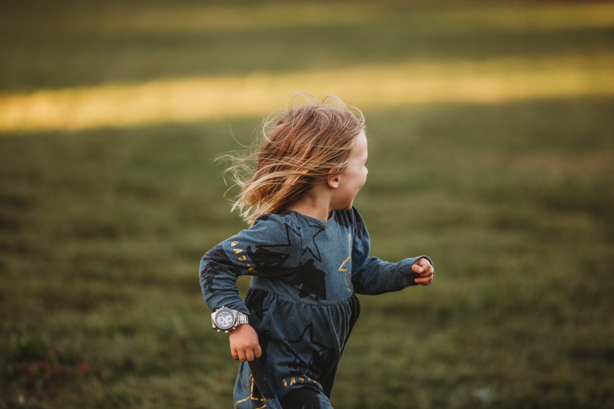 Action shot of young girl running while looking away from camera