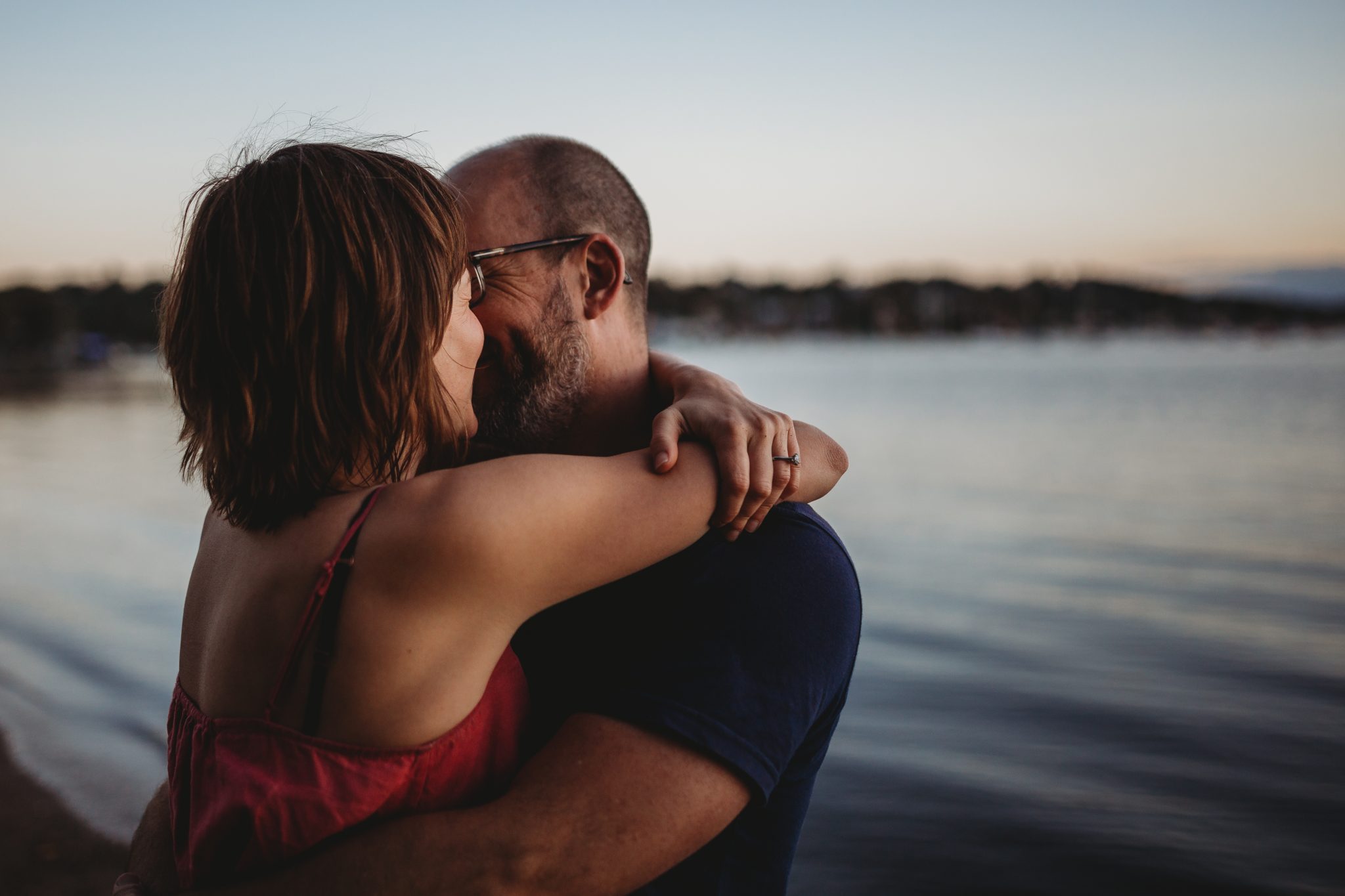 Woman and man hugging by Lake Macquarie