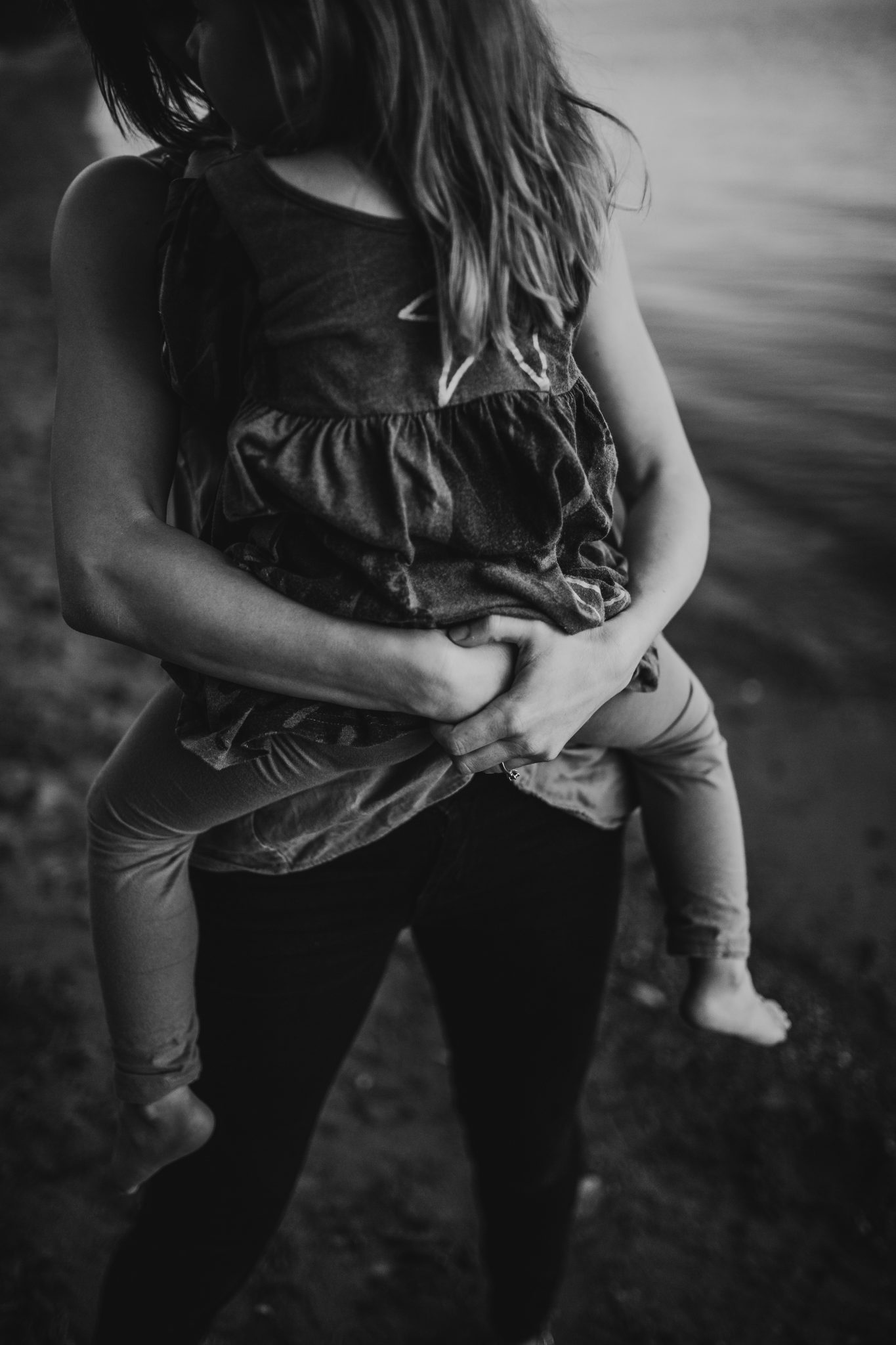 Black and white image of mother holding daughter in her arms