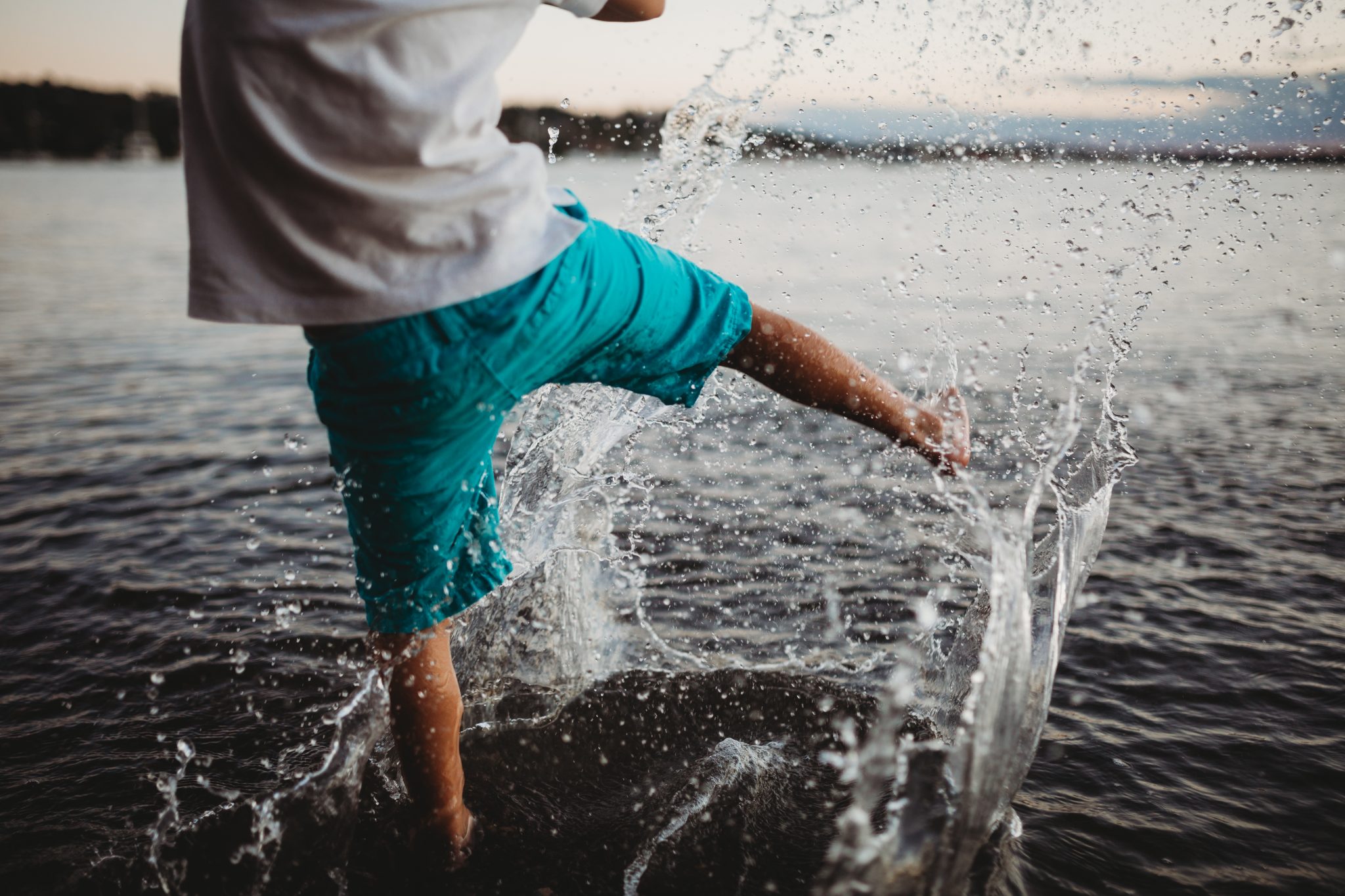 Young boy kicking and splashing water in Lake Macquarie