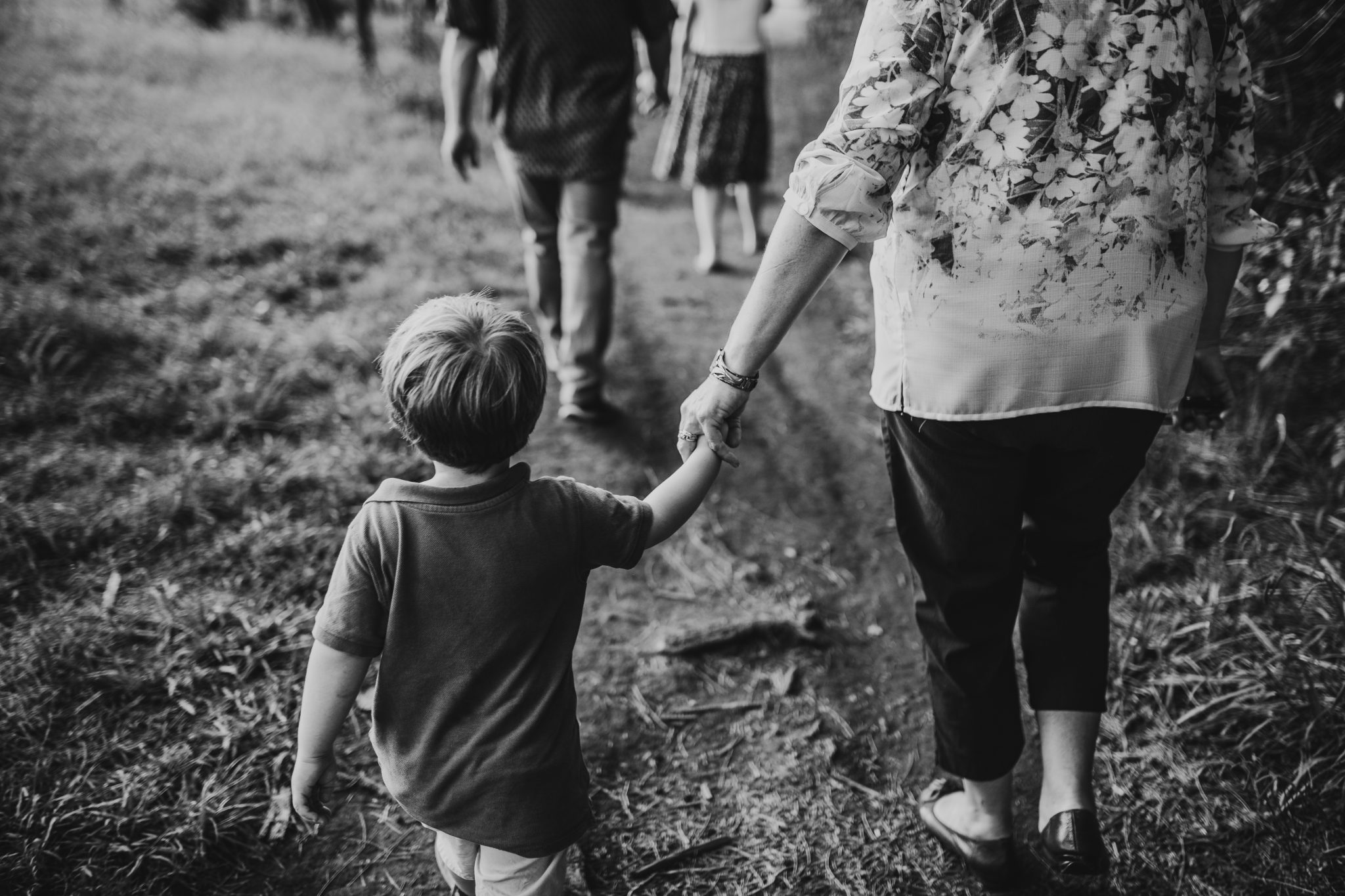 Young boy holding hands with his grandmother as they're walking