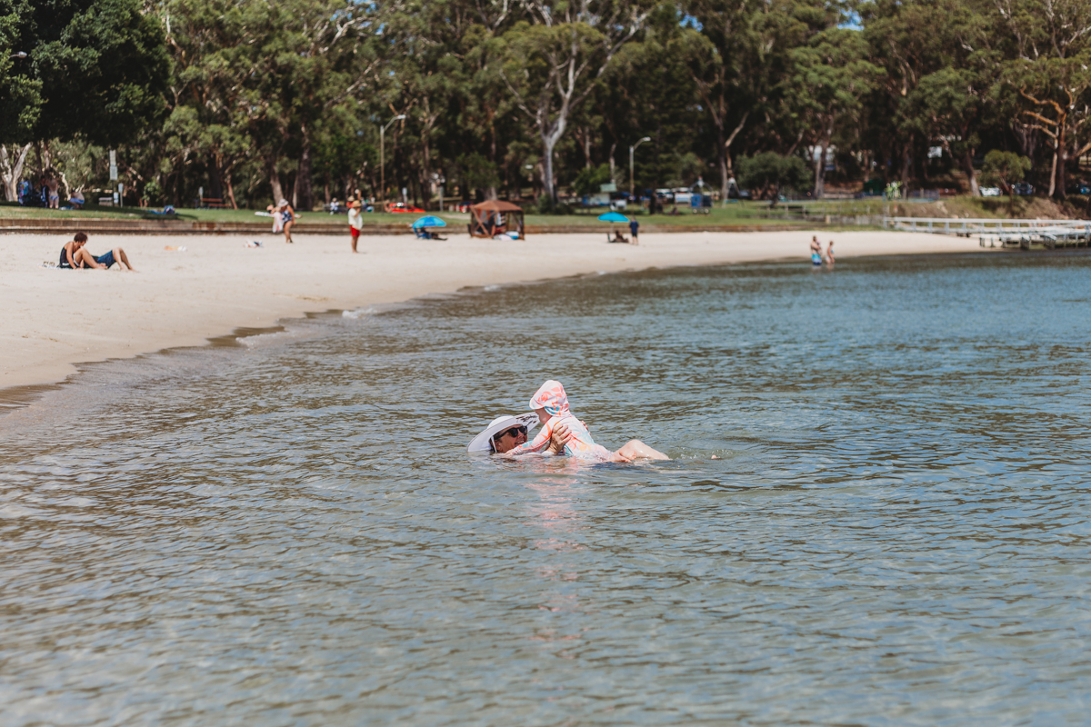 Grandmother and granddaughter swimming and playing in water at Shoal Bay