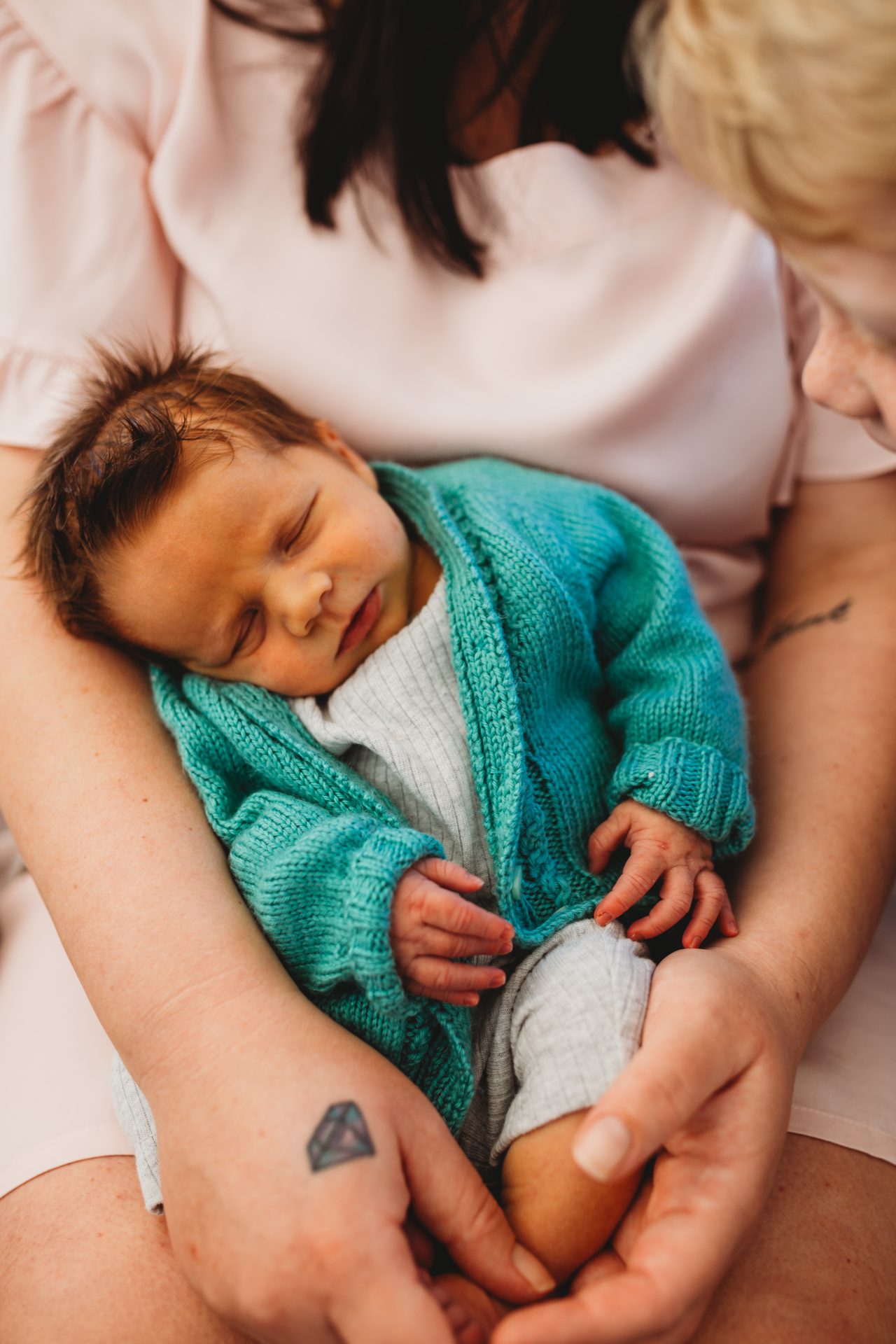 A newborn baby boy asleep in his mother's arms