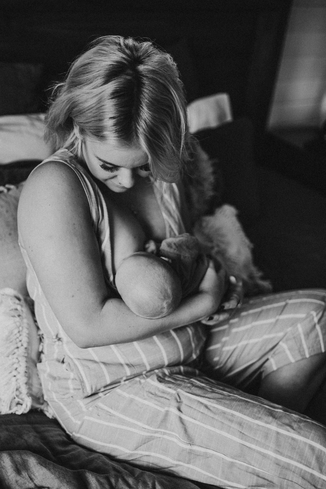 Black and white image of mother feeding newborn son