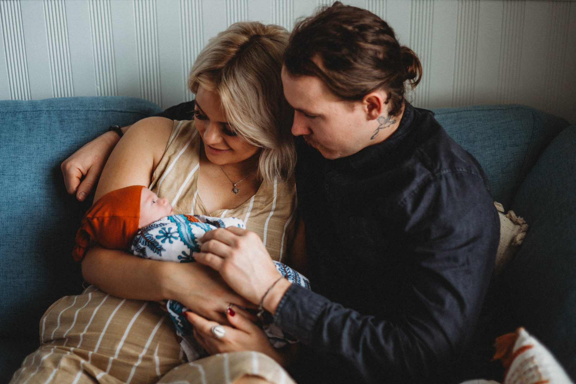 Young couple cuddled together, admiring baby son